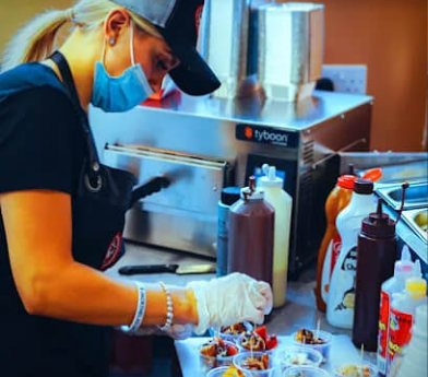 A staff preparing dessert in the Sweet Spot kitchen, a Mealzo EPOS partner