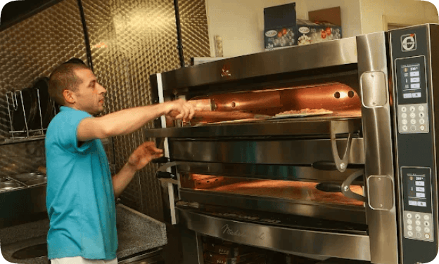 Staff is making pizza in Giulio's takeaway Falkirk