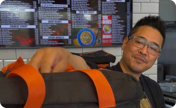Wok Ninja takeaway owner holding a Mealzo delivery bag